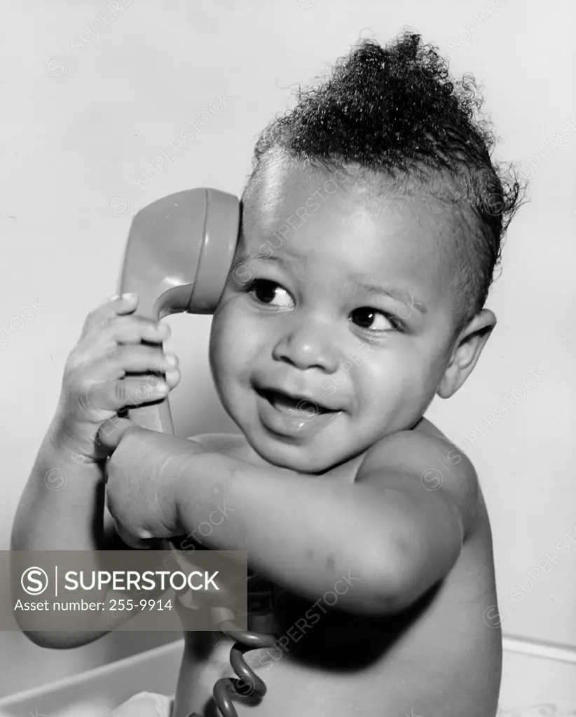Close-up of a baby holding a telephone receiver