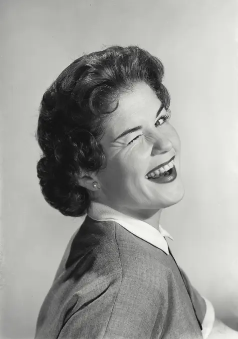 Vintage Photograph. Portrait of young woman winking.