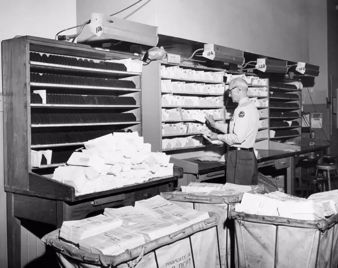 Postal worker sorting mail in a post office, USA