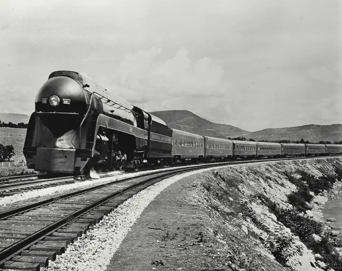 Vintage Photograph. Streamliner pulling cars coming around bend.