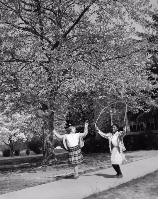 Vintage photograph of girls jumping with jump-rope in park