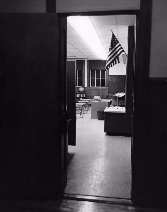 American flag seen from the door of a classroom
