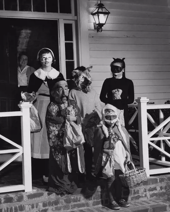Five children wearing Halloween costumes for trick or treating