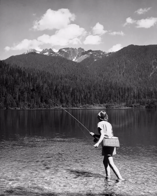 Rear view of a woman fishing in a lake, Baker Lake, Mount Baker-Snoqualmie National Forest, Washington, USA