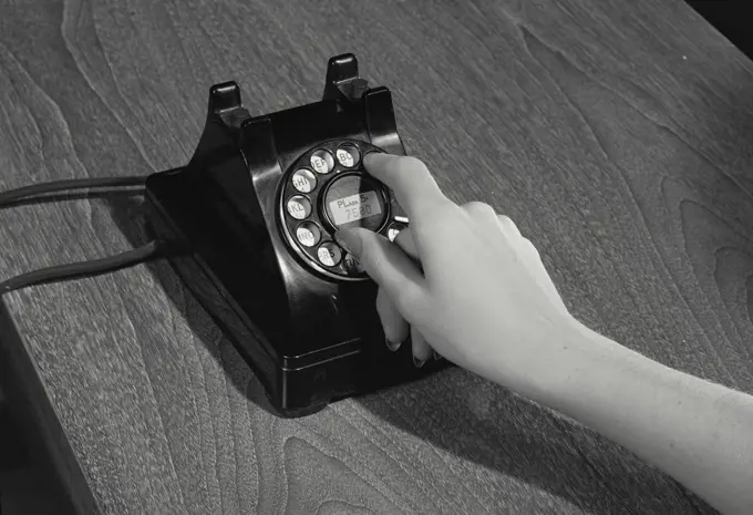 Woman's hands dialing rotary telephone
