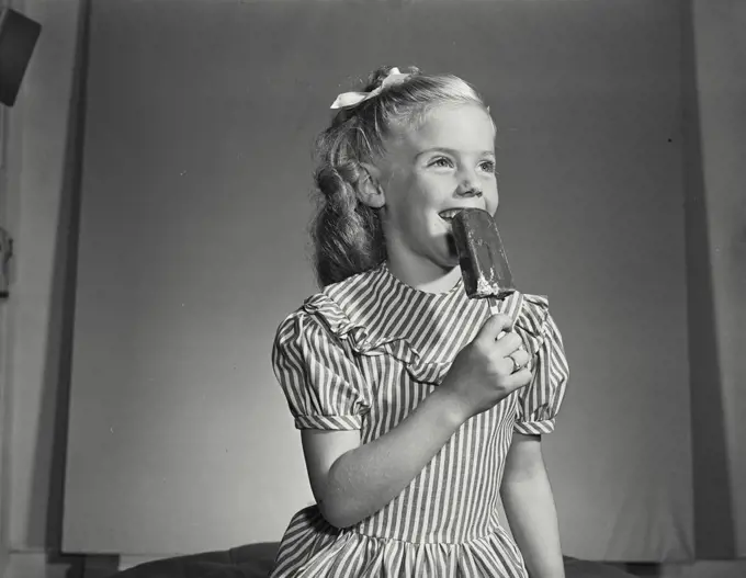 Vintage photograph. Little girl smiling with ice cream pop