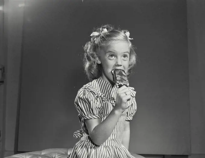 Vintage photograph. Little girl smiling with ice cream pop