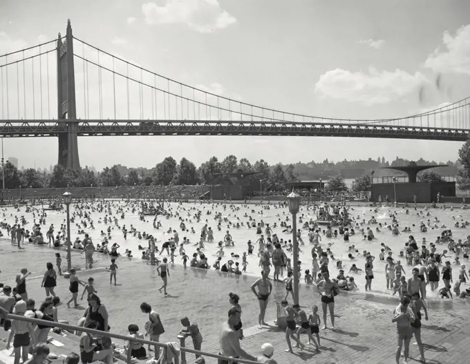 Vintage photograph. Astoria Park Pool. New York City. People playing in public pool with bridge in background