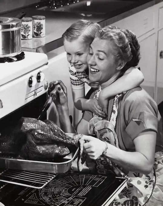 Mother preparing turkey with her son