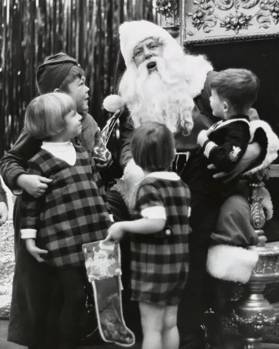 Portrait of Santa Claus talking with four children