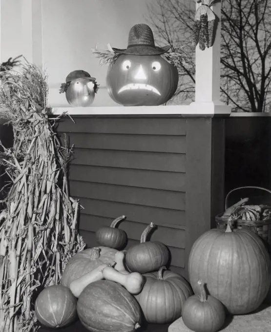 Illuminated jack o' lantern with pumpkins on a porch