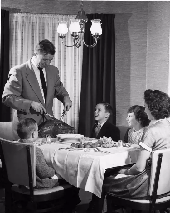 Mature couple with their children at dining table on Thanksgiving Day,