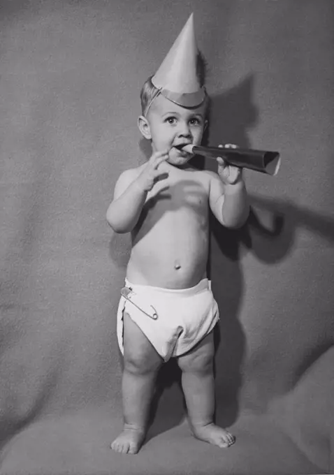 Portrait of a baby boy blowing a noisemaker