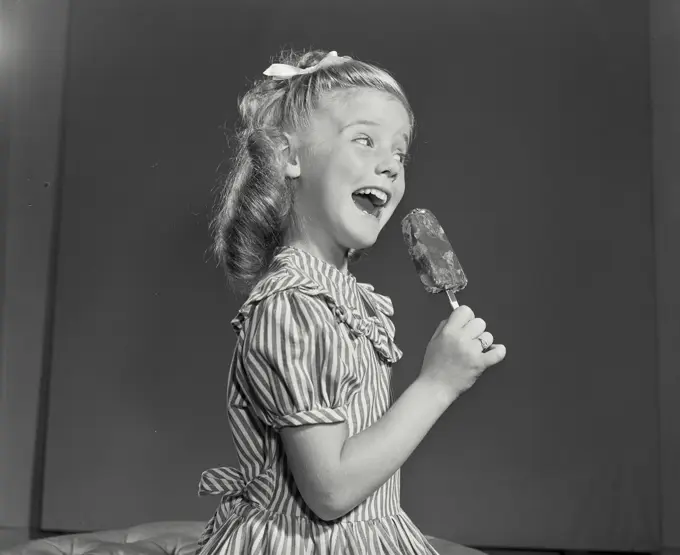 Vintage photograph. Side profile of a girl holding an ice-cream