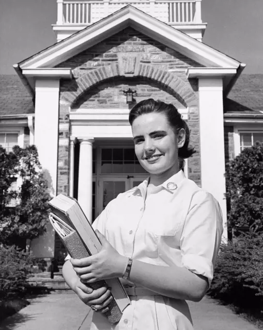 Teenage girl holding books and smiling