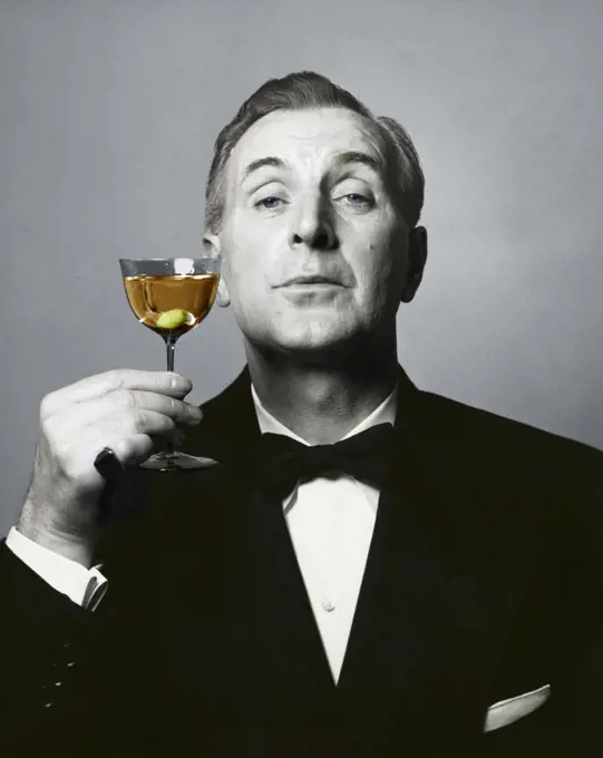Portrait of a mature man holding a martini