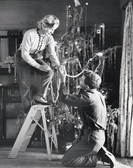 Young couple decorating a Christmas tree