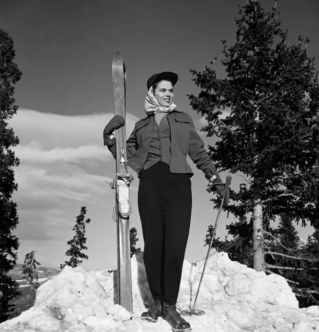 Woman holding skis and poles