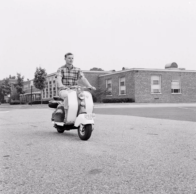 Young man driving scooter