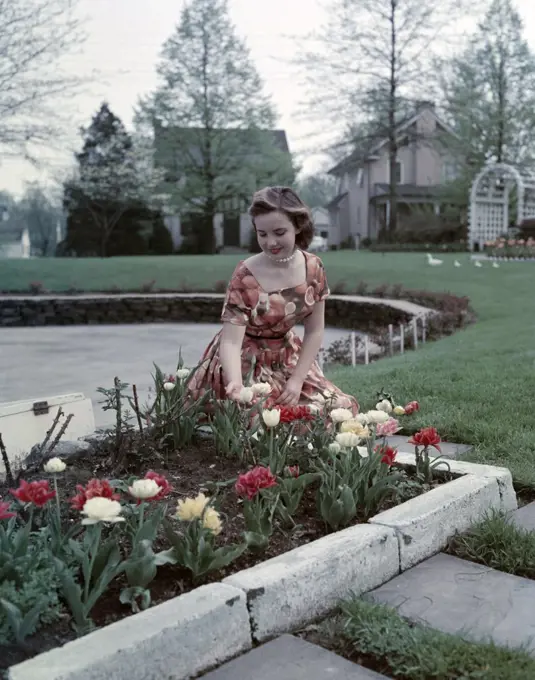 Woman tending flowers in yard