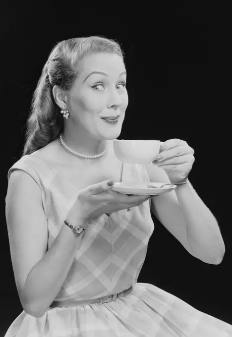 Studio portrait of young woman drinking tea.