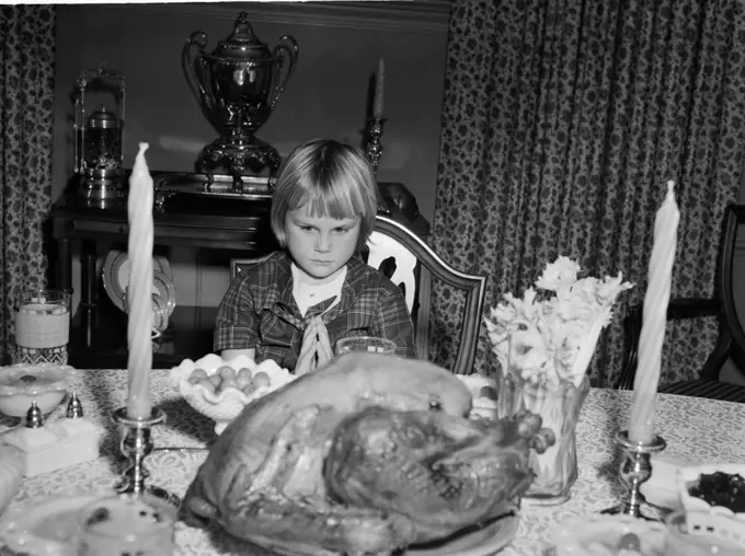 Girl praying before Thanksgiving meal
