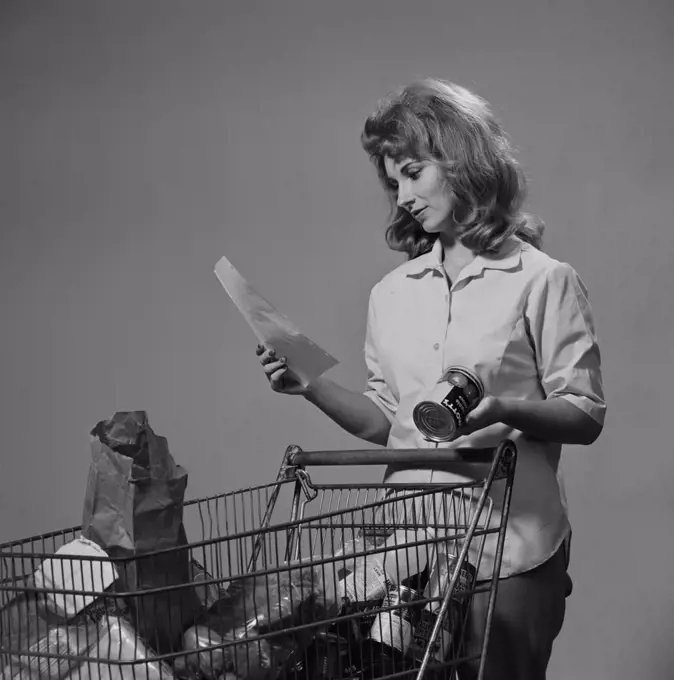 Young woman with groceries in shopping trolley