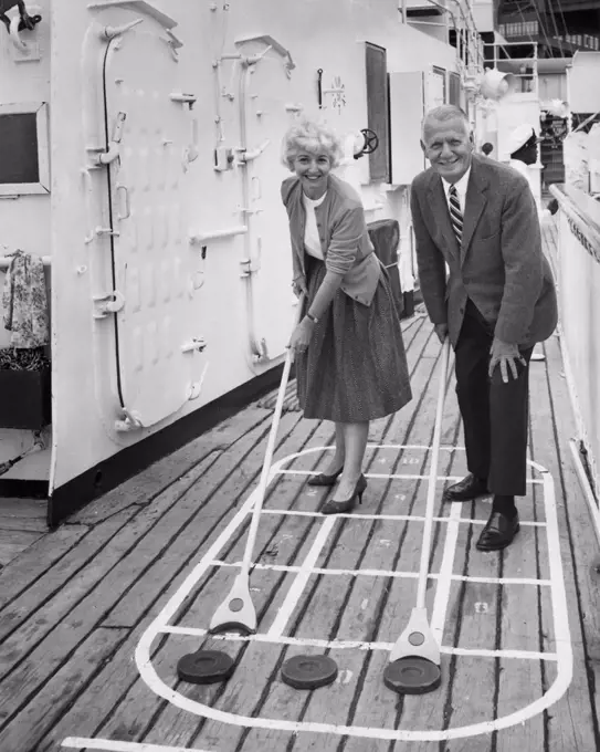 Senior couple playing shuffleboard on a cruise ship