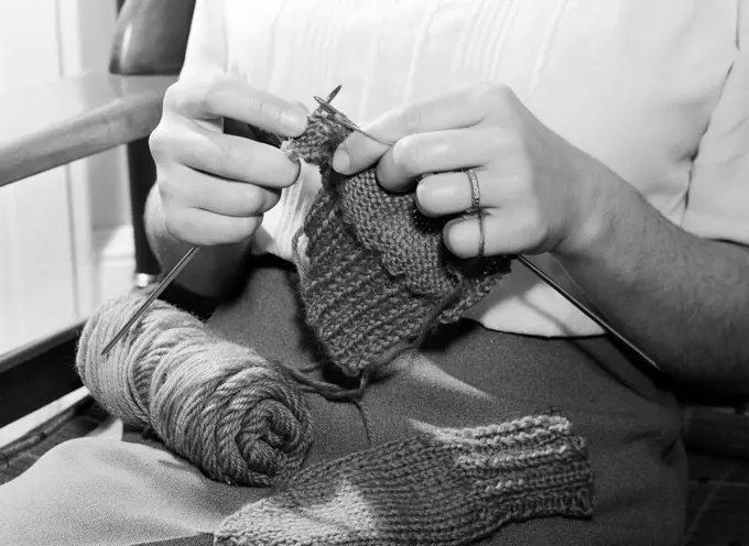 Mid section of woman knitting