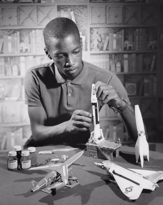 Teenage boy making a model rocket, 1964