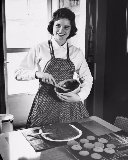 Young woman mixing chocolate in a bowl and smiling