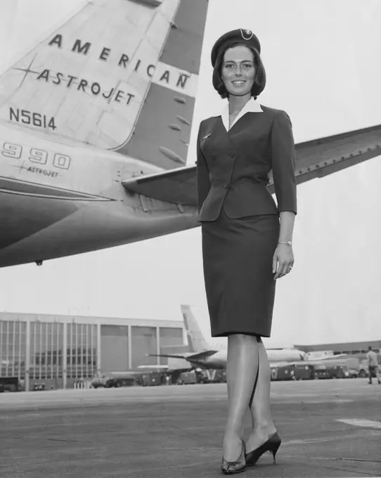 Portrait of a female cabin crew member standing near a airplane
