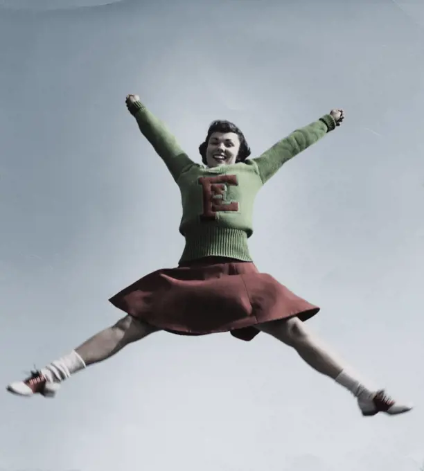 Female cheerleader jumping in air