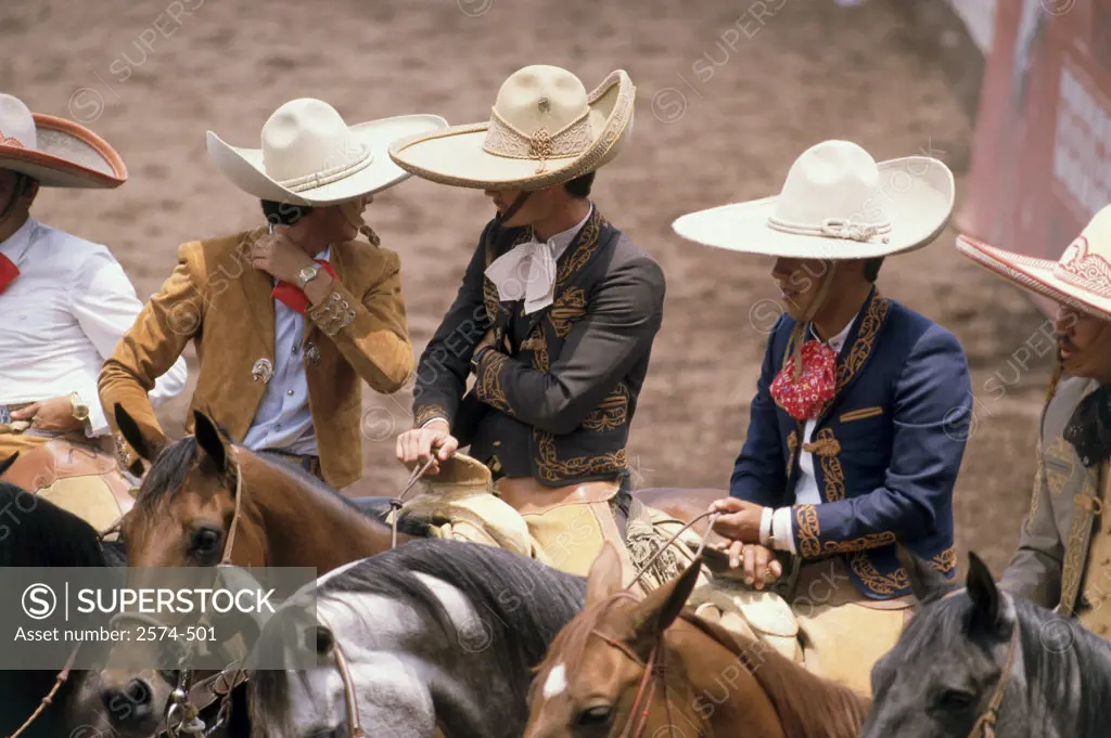 High angle view of five cowboys riding horses at a rodeo, Charreada, Mexico