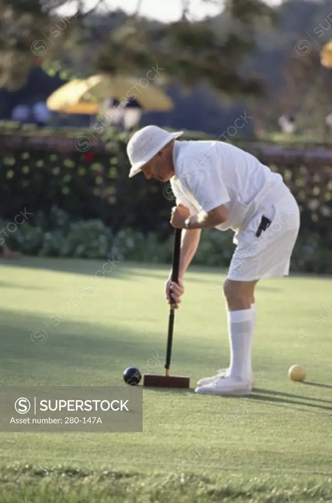 Senior man playing croquet