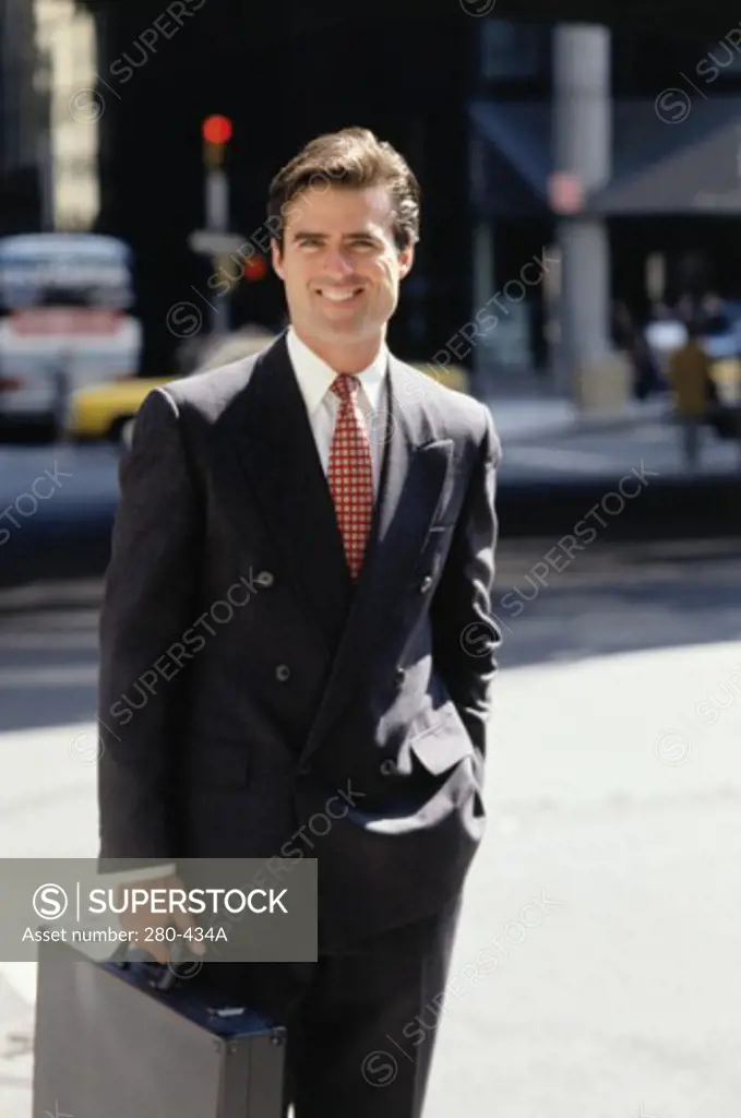 Businessman holding a briefcase and smiling