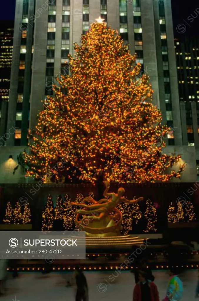 Christmas tree in front of a building lit up at night, Rockefeller Center, Manhattan, New York City, New York, USA
