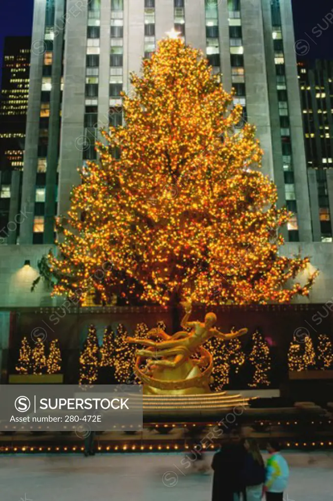Christmas tree in front of a building lit up at night, Rockefeller Center, Manhattan, New York City, New York, USA