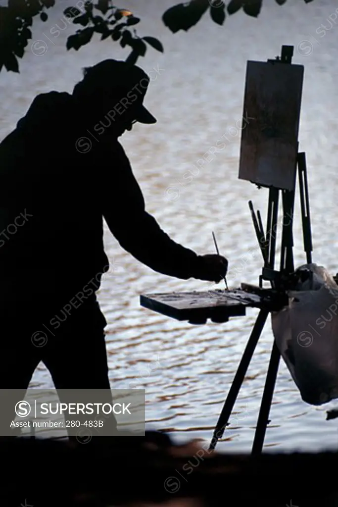 Silhouette of a man painting at dusk