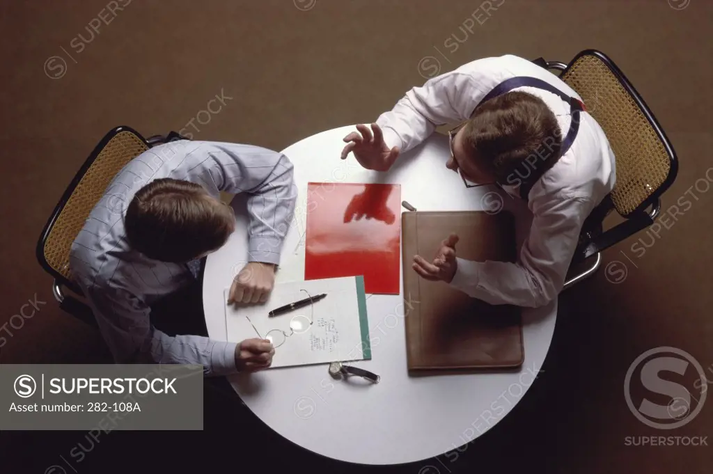 High angle view of two businessmen talking at a table