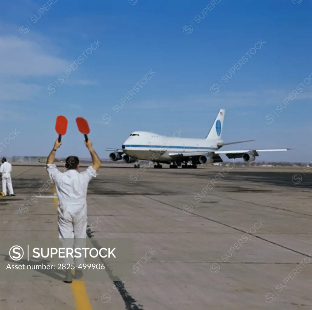 Signalman Bringing in 747 Airplane