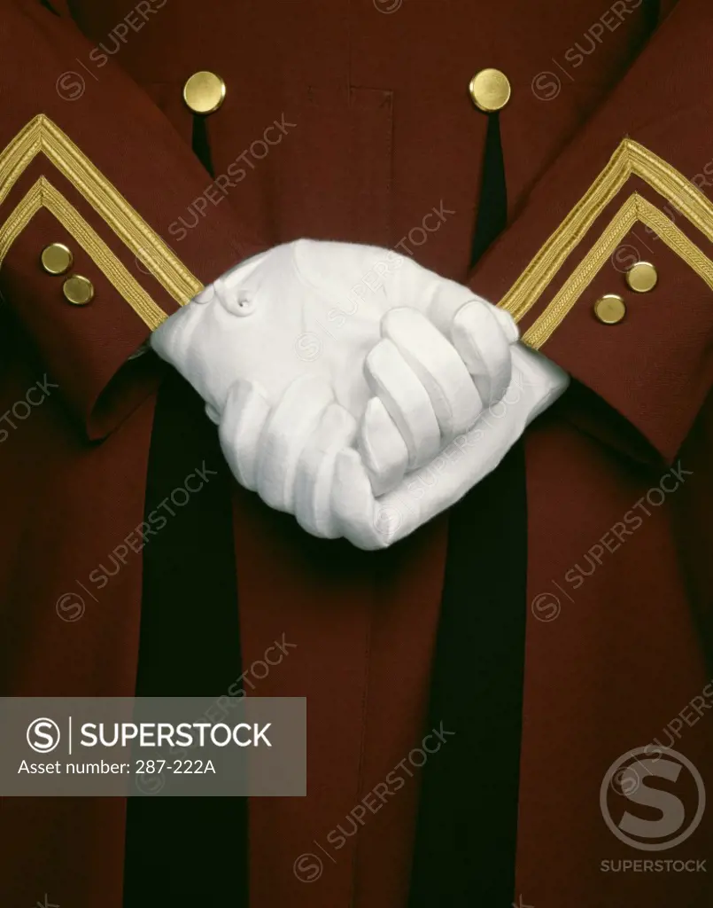 Mid section view of a bellhop with hands clasped