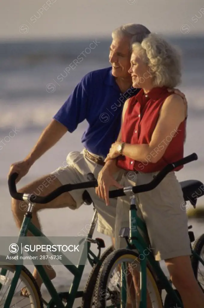 Senior couple with bicycles on the beach