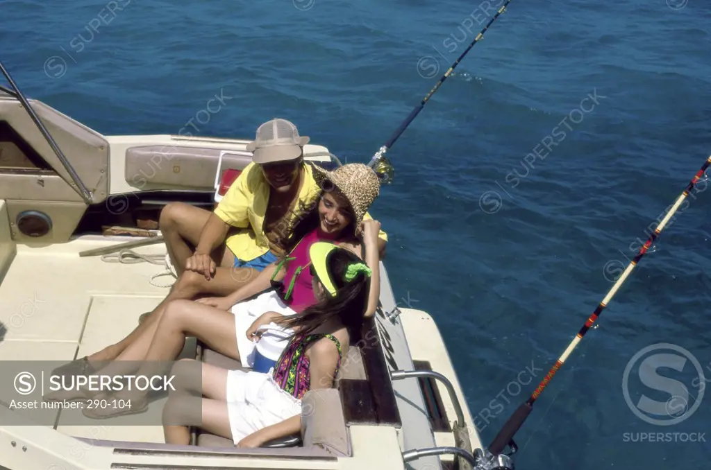 Young couple with their daughter sitting on a boat