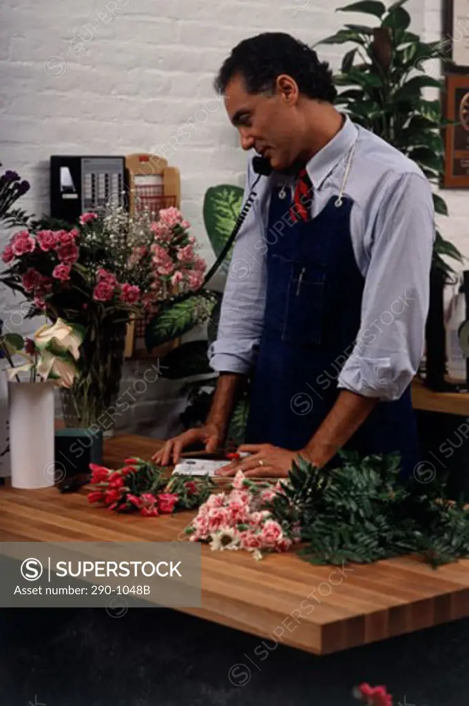 Male florist talking on the telephone in a flower shop