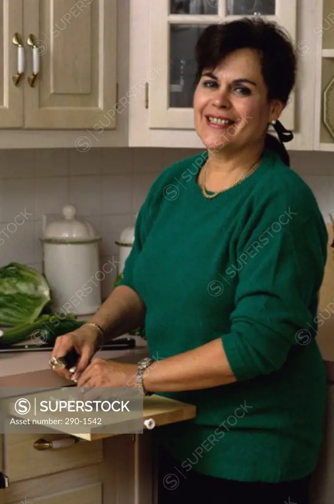 Mature woman standing in a kitchen and smiling