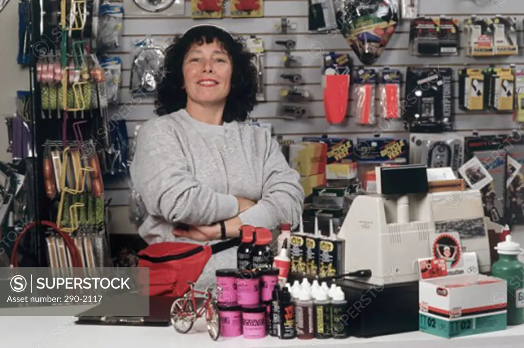 Portrait of a mid adult woman standing with her arms crossed in a bicycle shop