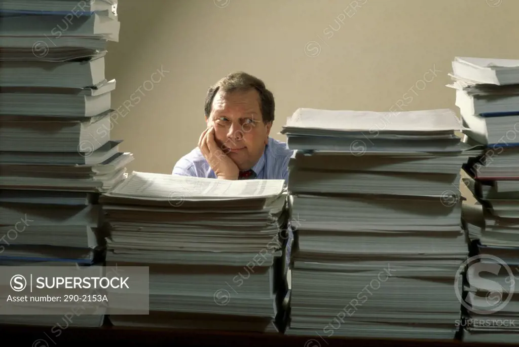 Businessman behind stacks of files