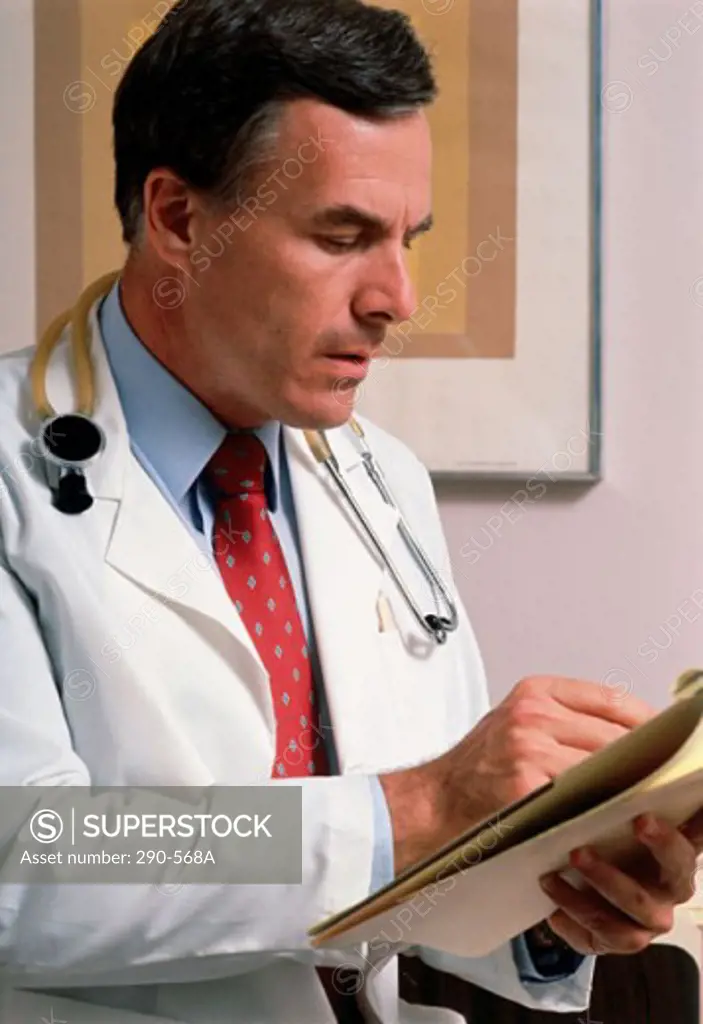Male doctor reading a report