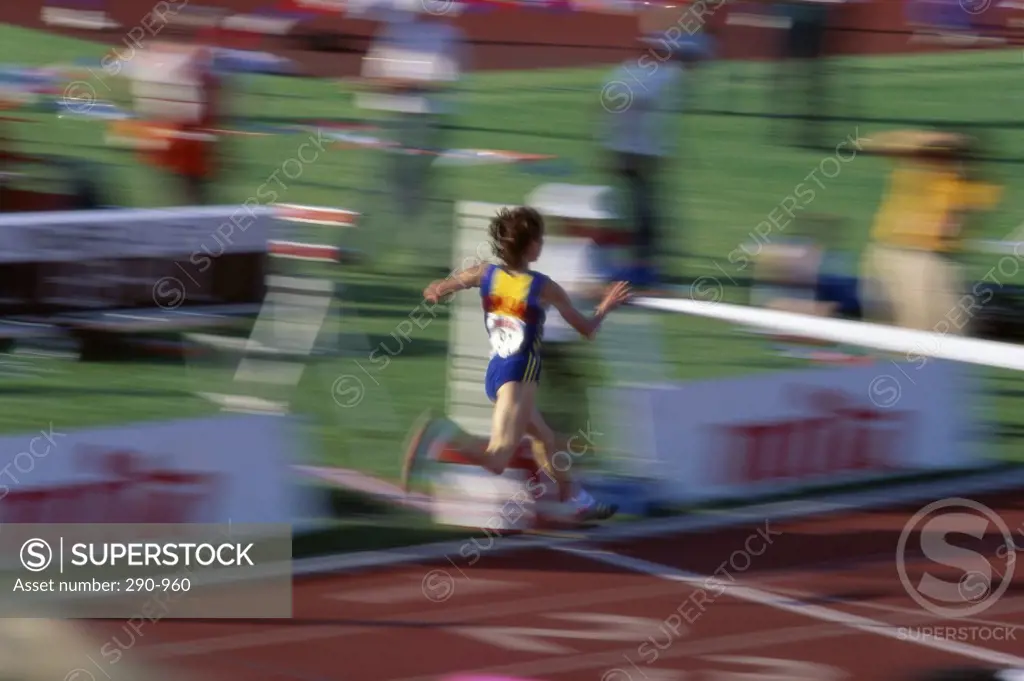 Rear view of a female athlete crossing the finish line